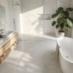 Nowoczesna jasna łazienka z marmuru z wanną wolnostojącą, prysznicem walk-in, dębową szafką i rośliną doniczkową.